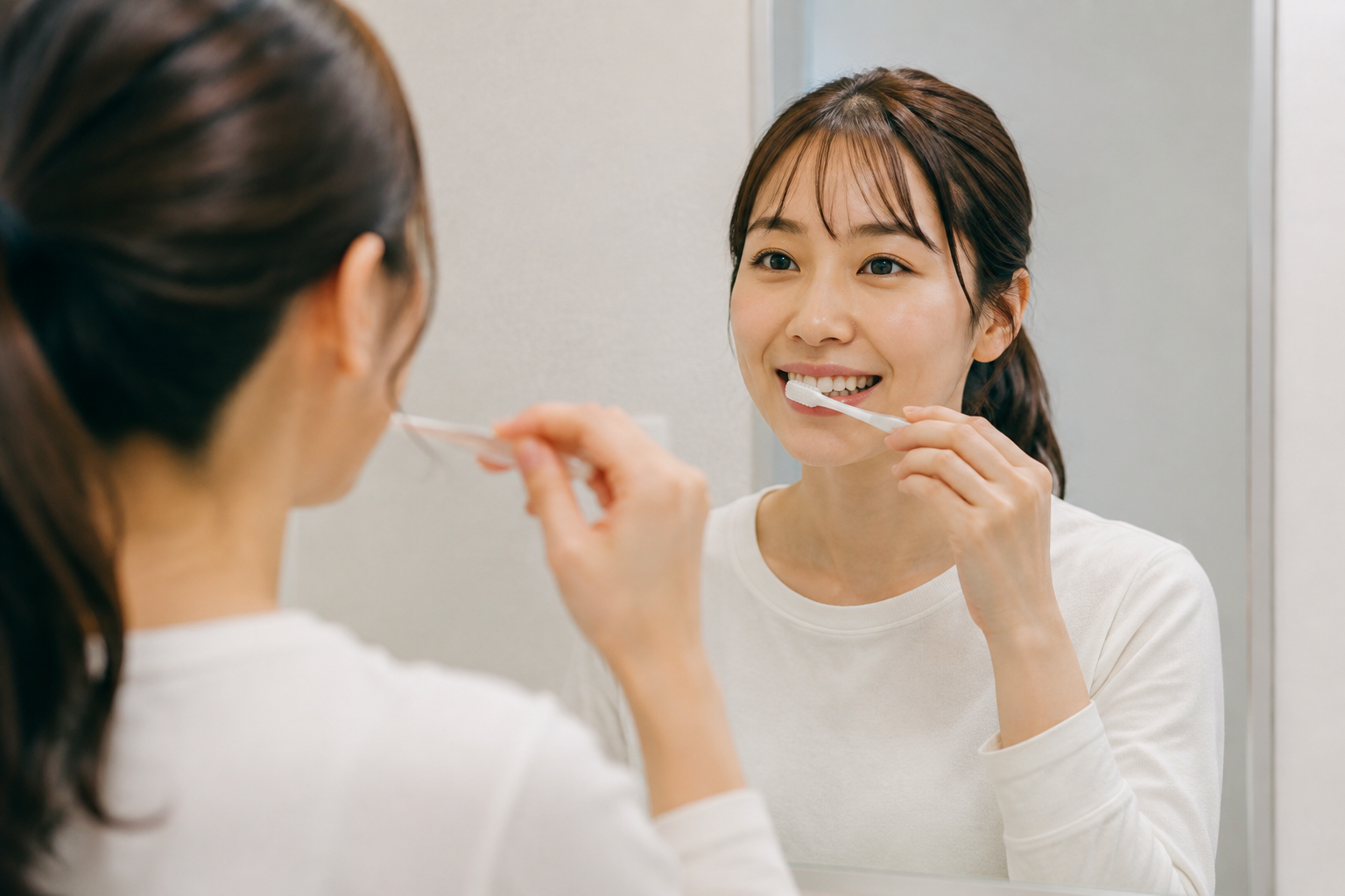 鏡を見ながら丁寧に歯を磨くイメージ