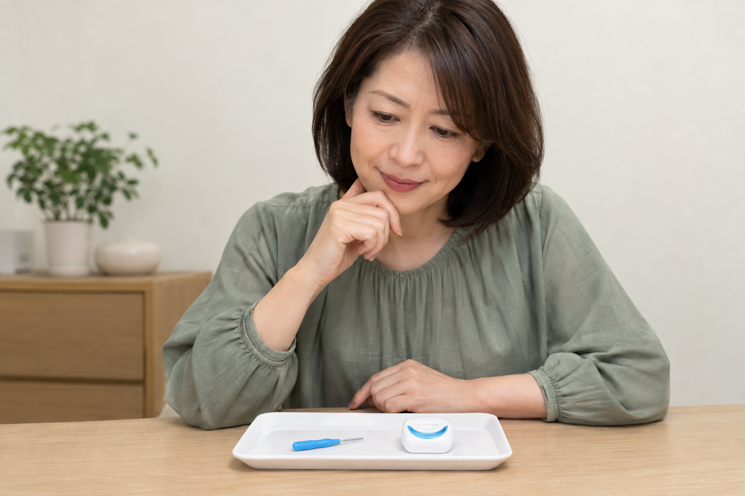 歯間ブラシとフロスを見比べてケア用品を選ぶ女性